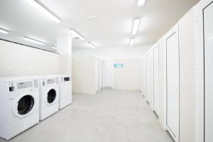 a white laundry room with washing machines and cabinets at Medora Orbis Camping Pitches in Podgora