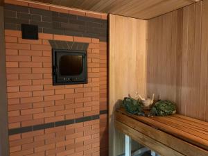 a room with a tv on a brick wall at Pirties namelis Paliekys in Lekėčiai