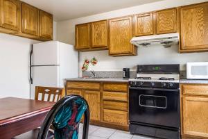 a kitchen with wooden cabinets and a black stove at Auburn House Hotel in Auburn