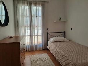 a bedroom with a bed and a dresser and a window at Bella Vita Ixia in Ixia +6 photos