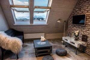 Silverton - blisko stoku, sauna, mini siłownia, przyjazny rodzinom في بيالكا تاترزانسكا: غرفة معيشة مع أريكة وتلفزيون