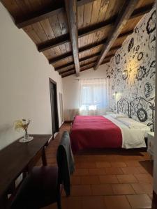 a bedroom with a large bed with a red blanket at Locanda Sul Lago in Santo Stefano di Sessanio