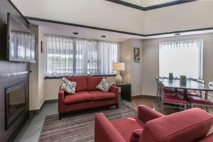 a living room with a red couch and a table at Comfort Inn in Sydney +26 photos