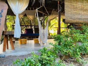 a hammock hanging from a tent in a garden at Nông Trại Thảnh Thơi in Ben Tre