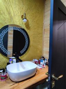 a bathroom with a white sink and a mirror at Wooden house nica in Lagami