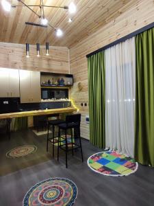 a kitchen with green curtains and a table with chairs at Wooden house nica in Lagami