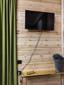 a flat screen tv hanging on a wooden wall at Wooden house nica in Lagami