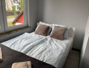 een bed in een kamer met een raam bij Przystanek Karpacz - Komuny Paryskiej 3 in Karpacz