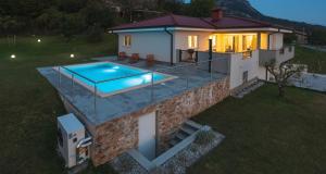 a house with a swimming pool on top of it at Villa Vitovlje in Vitovlje
