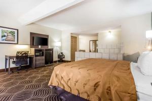 a hotel room with a large bed and a desk at Quality Inn Black Mountain-Asheville East in Black Mountain