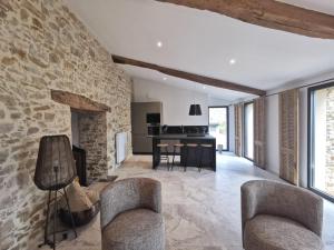 an open living room with a stone wall at Villa Beauchêne in Le Landreau