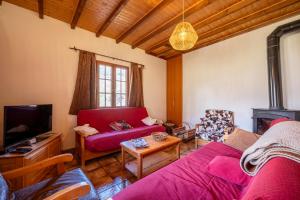a living room with a red couch and a tv at Chalet Savoiage - 13 personnes in Saint-Colomban-des-Villards