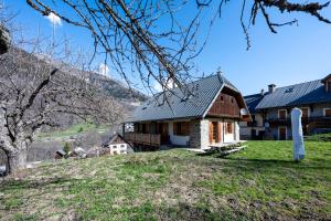 a house on the side of a hill with a tree at Chalet Savoiage - 13 personnes in Saint-Colomban-des-Villards