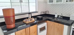 a kitchen with a black counter top and a sink at Casa próxima ao Parque das Águas in São Lourenço