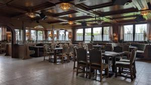a dining room with tables and chairs and windows at Cafe zum Toni in Thyrnau