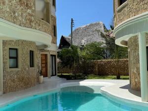 a house with a swimming pool next to a building at Casa Eywa at Ghepard Towers in Watamu