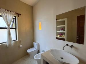 a bathroom with a sink and a toilet and a mirror at Casa Eywa at Ghepard Towers in Watamu +12 photos