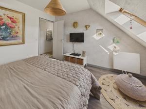 a bedroom with a large bed and a television at Bel appartement avec balcon pour 3 personnes in Fouesnant