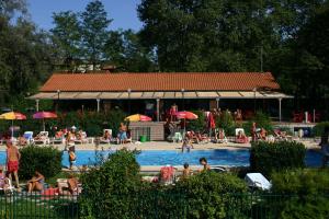 a group of people sitting in a swimming pool at Dkamping Village in Ispra