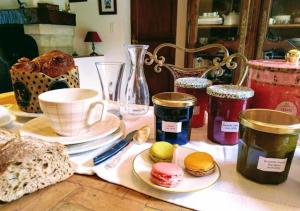 a table with cups and plates of pastries on it at Chambres entre Romorantin-Chambord-Zoo de Beauval - Orée du Bois en Sologne in Lassay-sur-Croisne +25 photos