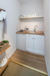 a kitchen with white cabinets and a sink at Friedrich Inn in Norderney