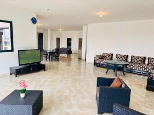 a living room with couches and a flat screen tv at Villa Pour 6pers, 10 min des plages, proche Aéroport Beziers et autoroutes in Villeneuve-lès-Béziers