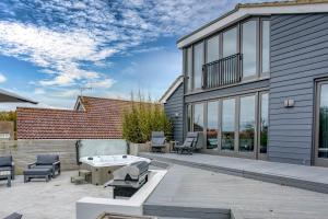 a patio with a table and chairs and a building at The Retreat Luxury Coastal Villa near Sandringham Crabpot Cottages Hunstanton in Dersingham