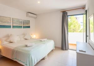 a bedroom with a bed and a large window at Es Dolç Apartments by YouRoom in Colonia Sant Jordi
