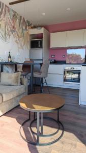 a living room with a table and a kitchen at AMARRÉ Gîte Bambou T2 Chambre indépendante in Sarzeau +16 photos