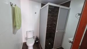 a small bathroom with a toilet and a shower at Habitación en el rodadero a solo pasos del mar in Gaira
