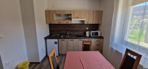 a small kitchen with a table and a microwave at Relax House Samardzic in Ličko Petrovo Selo