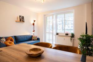 a living room with a table and a blue couch at Atelierwohnung am Stadtpark in Chemnitz