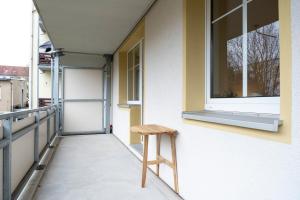 a stool sitting on the side of a building with a window at Atelierwohnung am Stadtpark in Chemnitz