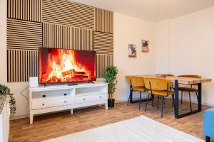 a living room with a tv and a table with a fireplace at Atelierwohnung am Stadtpark in Chemnitz