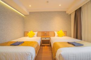 a hotel room with two beds with yellow pillows at Osaka Kansai Airport Hotel Kansai Airport 2 station in Izumi-Sano +74 photos