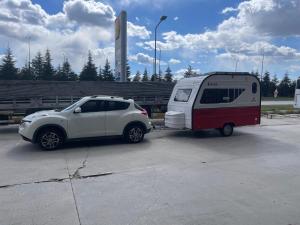 a small car parked next to a trailer at Caravan in the Cappadocia Valley in Nar