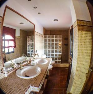 baño con 2 lavabos y espejo grande en Green Peaks B&B Country House Alojamiento Rural, en Granada