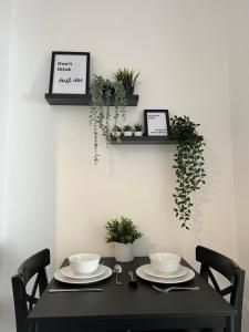 a black table with two chairs and plants on a wall at ResiLets - Brighton Road, Central, 2 Mile From NCL in Gateshead +36 photos