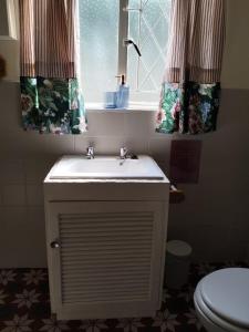 a bathroom with a sink and two windows at Primula Cottage at Hillhouse in Hilton +50 photos