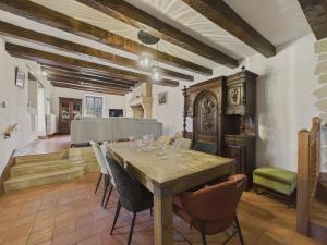 una sala da pranzo con tavolo e sedie in legno di Jolie maison avec jacuzzi pour 8 personnes a Mauzens-et-Miremont