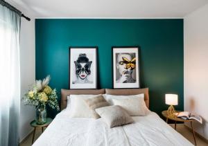 a bedroom with a green accent wall with a bed at Villa Vitovlje in Vitovlje