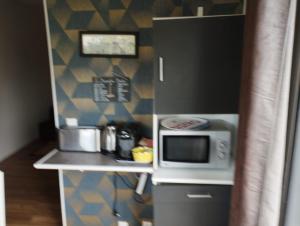 a small kitchen with a microwave on a counter at un îlot de calme in Morlaix