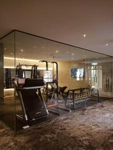 a glass room with a gym with a treadmill at BaBa Boutique House Langkawi in Pantai Cenang +62 photos