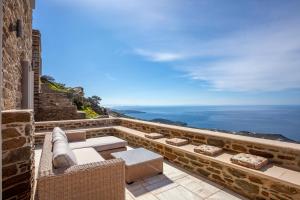 a view of the ocean from the balcony of a house at Olea Tinos, A Luxury Villa in Kardiani