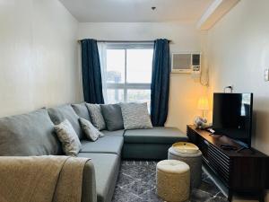 a living room with a couch and a television at 1 Bedroom Unit In Bamboo Bay in Mandaue City