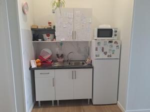 a small kitchen with a sink and a refrigerator at Pension Diana 2 in O Pedrouzo