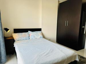 a bedroom with a bed and a black cabinet at 1 Bedroom Unit In Bamboo Bay in Mandaue City +17 photos