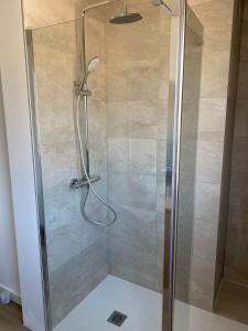 a shower with a glass door in a bathroom at Le Nid - Maison proche de la forêt in Frouard