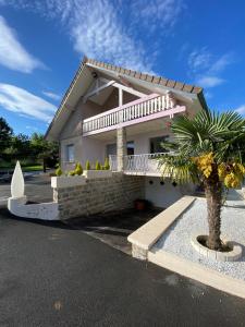 a house with a palm tree in front of it at Comme dans le sud in Boulot