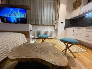 a bedroom with a bed and two stools and a tv at Tiny Nest - Sava Center, Belgrade in Belgrade
